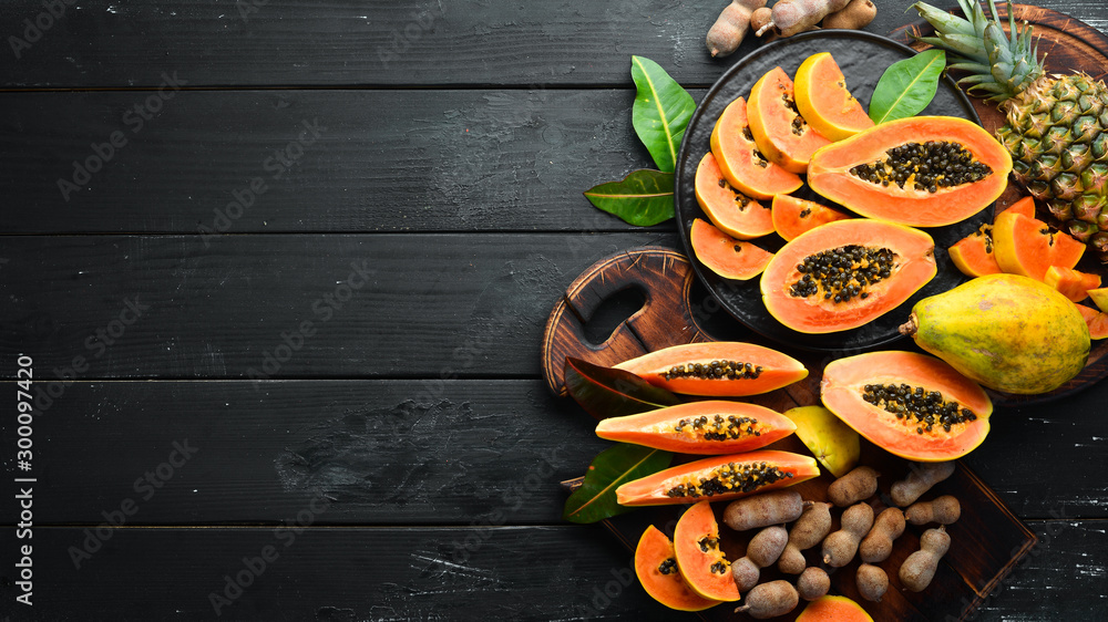 Papaya. Sliced papaya, on a wooden board. Tropical Fruits. Top view. Free space for text. Papaya. Sliced papaya, on a wooden board. Tropical Fruits. Top view. Free space for text.