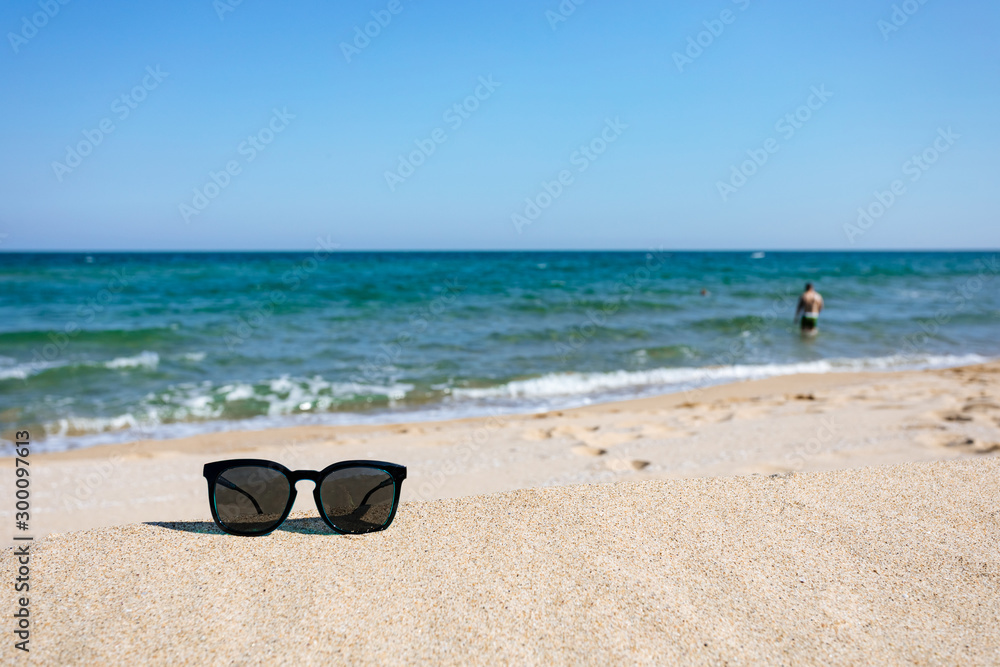 Sunglasses on sandy beach, black sea