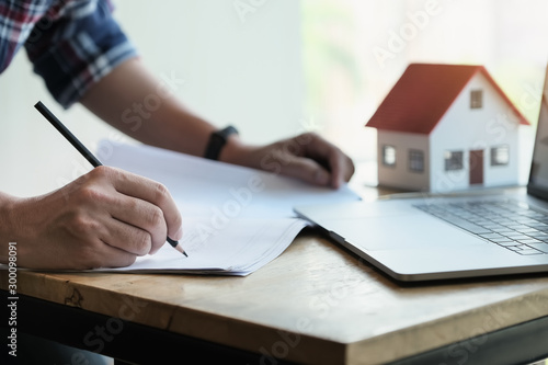 Engineer are planning to drawing house structure on Blueprint and sketch house on computer for his customers.