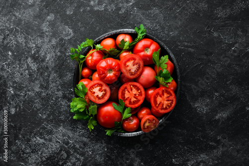 Foto Tomatoes in a plate on a black stone background