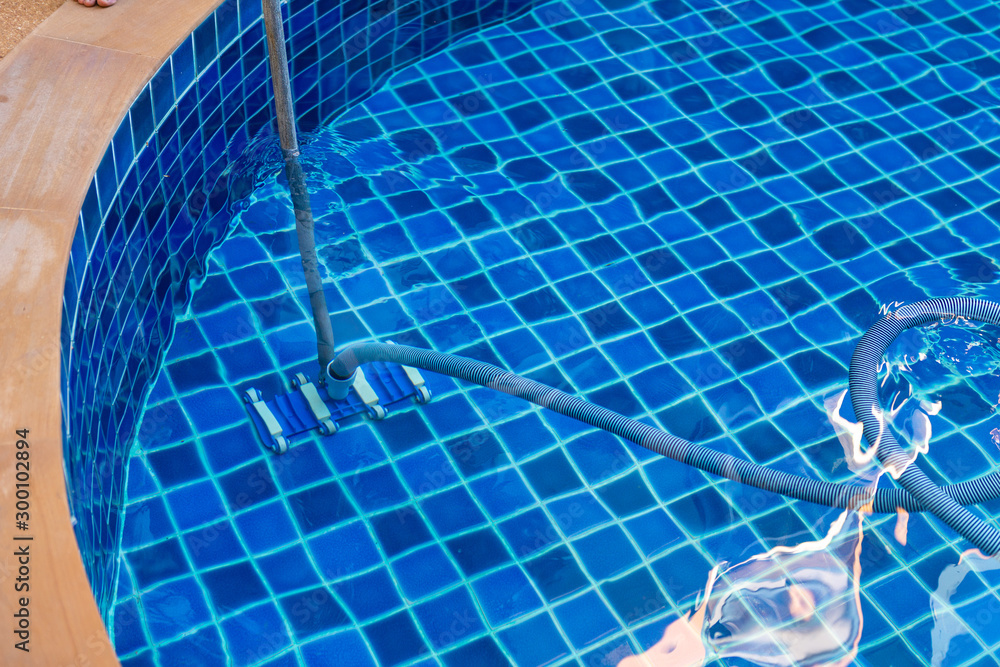 Cleaning the pool with vacuum cleaner.