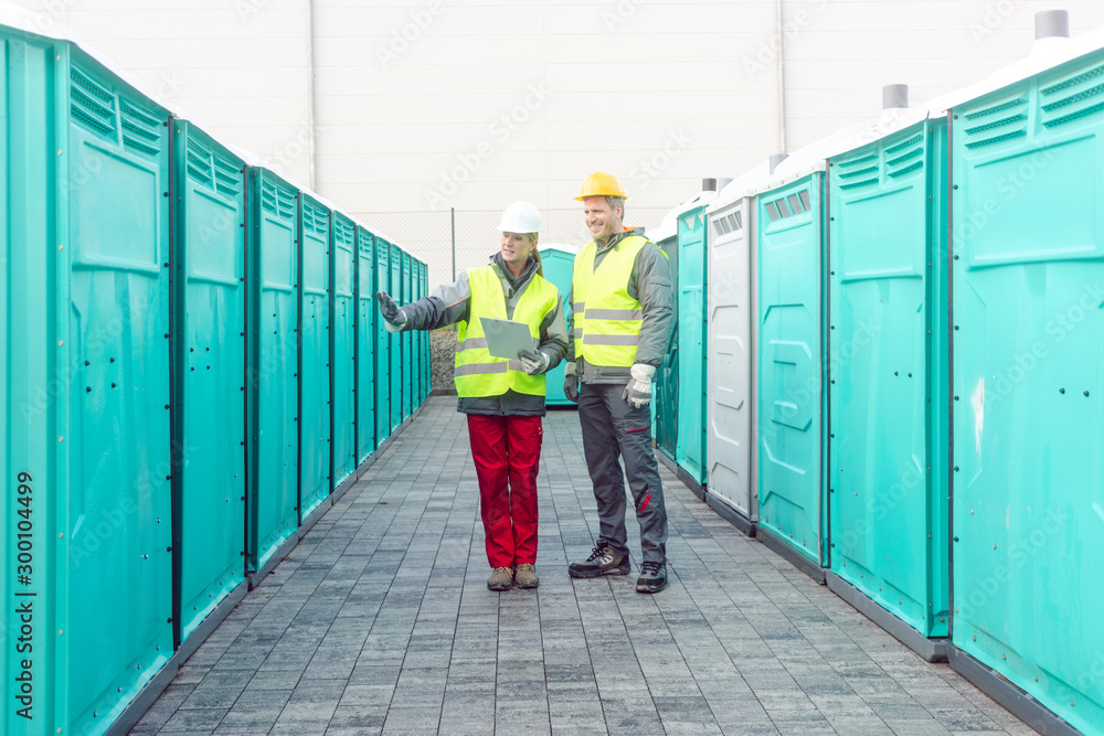Workers checking the portable toilets for rental - obrazy, fototapety, plakaty 