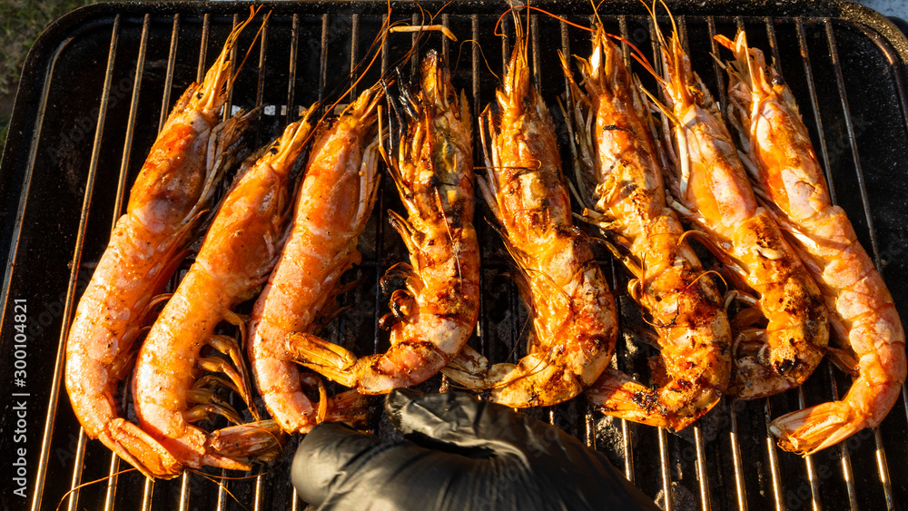 Tasty big shrimps langoustines cooking on fire barbecue.