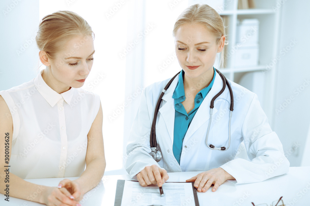 Doctor and patient talking in hospital office while sitting at the desk. Health care and client service in medicine Doctor and patient talking in hospital office while sitting at the desk. Health care and client service in medicine