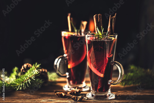 Tableau sur toile Mulled wine with spices in glasses on a rustic wooden table