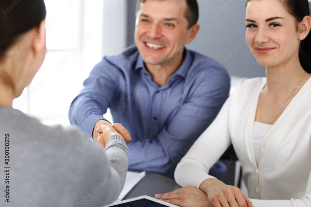 Group of business people shaking hands after discussing questions at meeting in modern office. Handshake close-up. Teamwork, partnership and agreement in business concept Group of business people shaking hands after discussing questions at meeting in modern office. Handshake close-up. Teamwork, partnership and agreement in business concept