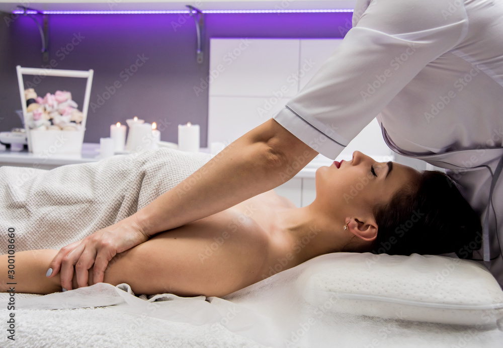 Fototapeta premium Beautiful young woman enjoying massage in spa salon. Cosmetology