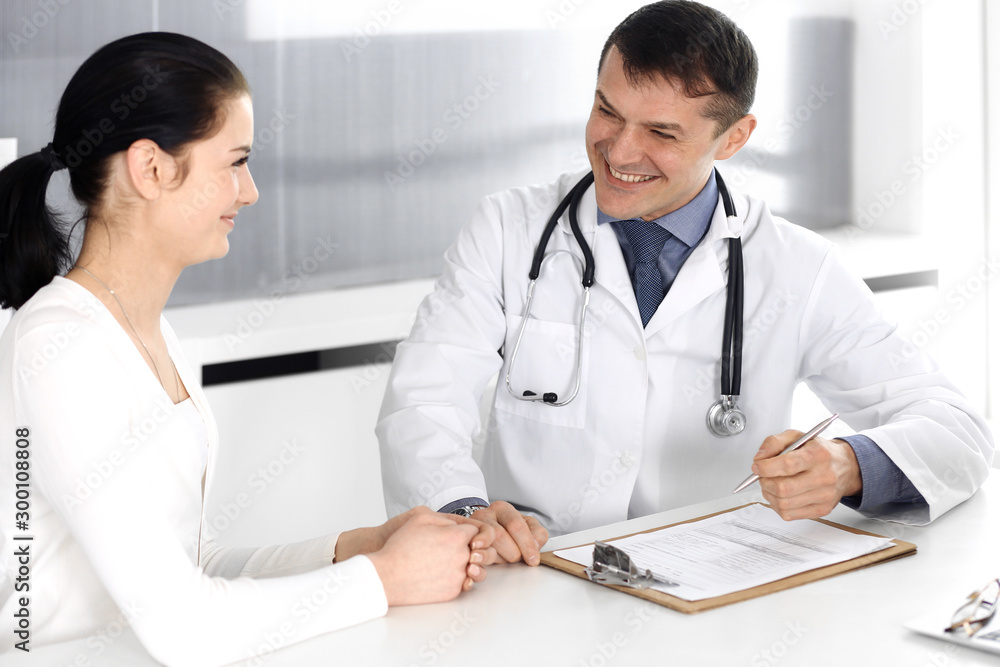 Doctor and patient discussing medical exam resoults at hospital office. Physician using clipboard for filling up medication history records. Perfect medical service in clinic. Medicine and healthcare Doctor and patient discussing medical exam resoults at hospital office. Physician using clipboard for filling up medication history records. Perfect medical service in clinic. Medicine and healthcare