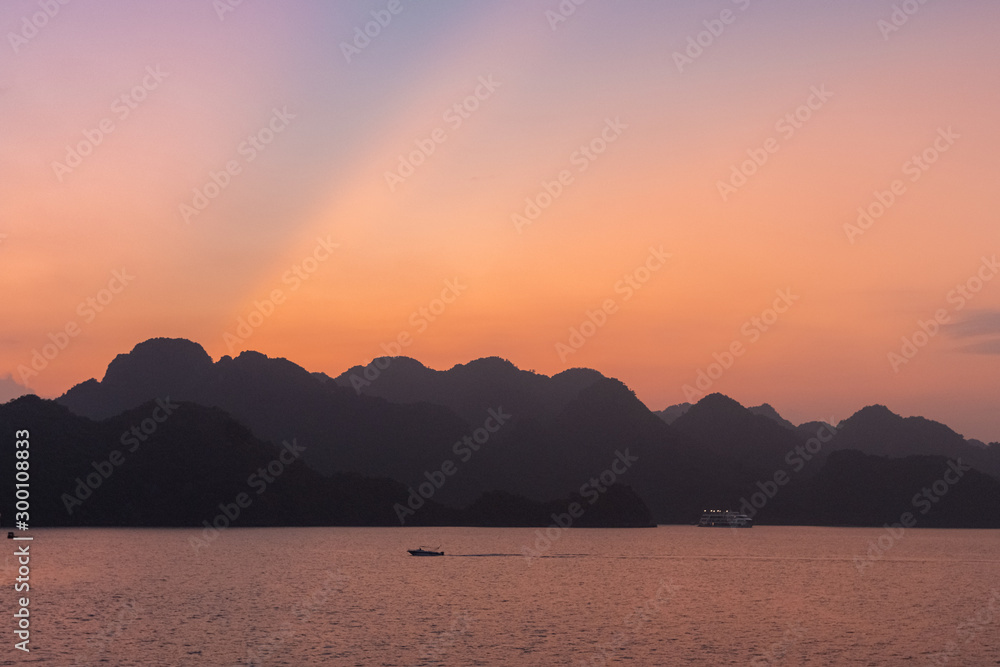 Ha Long Bay in Vietnam during a beautiful Sunset with calm, tranquil seas. Shot in Autumn 2019 from a cruise ship tour