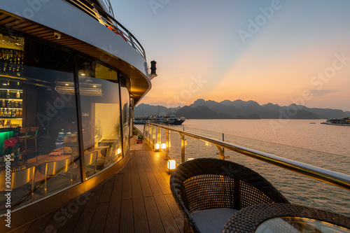 5 Star luxury on new modern Cruise Ships on Ha Long Bay, Vietnam looking over the stunning limestone rocks at Sunset photo