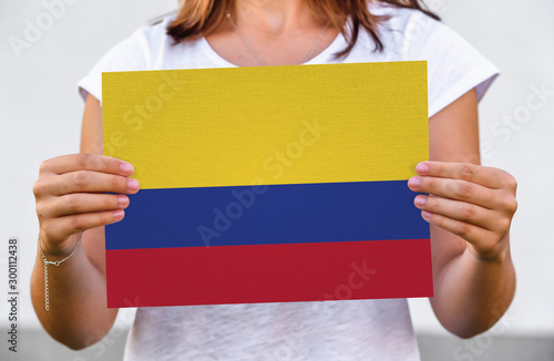 woman holds flag of Colombia on paper sheet