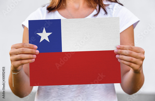 woman holds flag of Chile on paper sheet