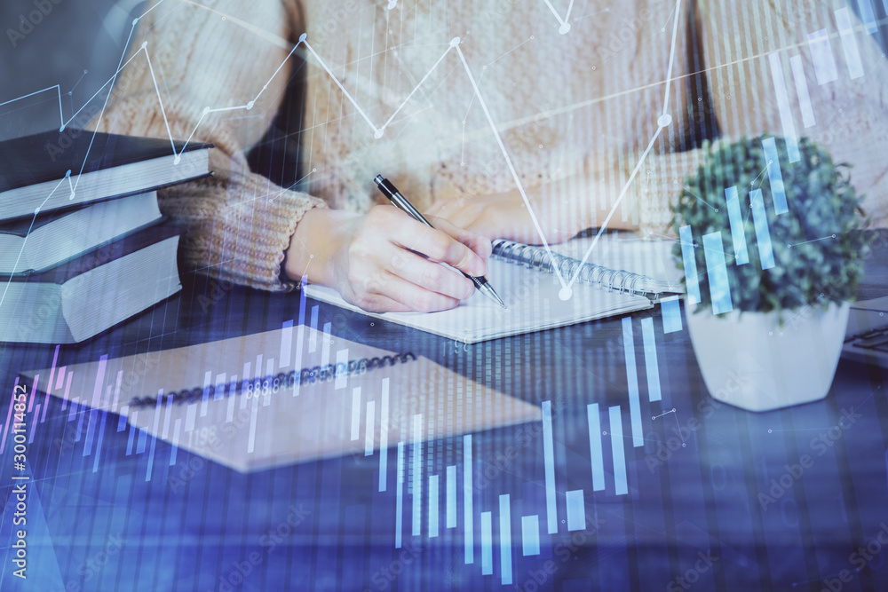 Forex graph on hand taking notes background. Concept of research. Double exposure Forex graph on hand taking notes background. Concept of research. Double exposure