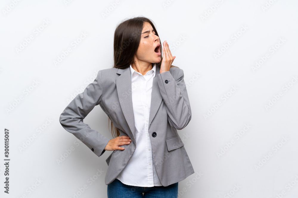 Young business woman over isolated white background yawning and covering wide open mouth with hand Young business woman over isolated white background yawning and covering wide open mouth with hand