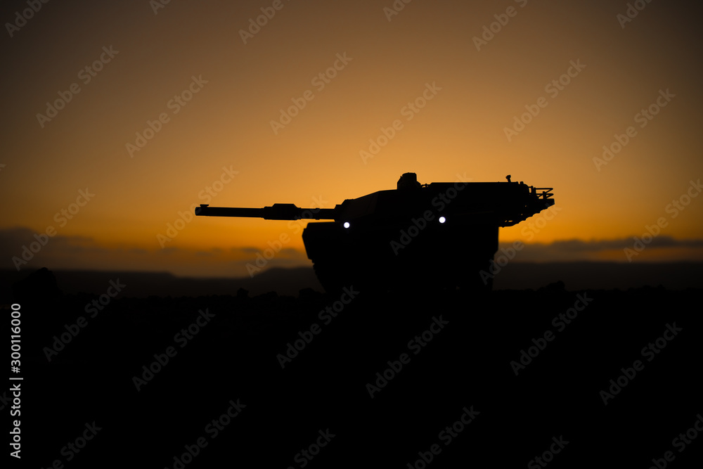 War Concept. Armored vehicle silhouette fighting scene on war fog sky background. American tank at sunset.