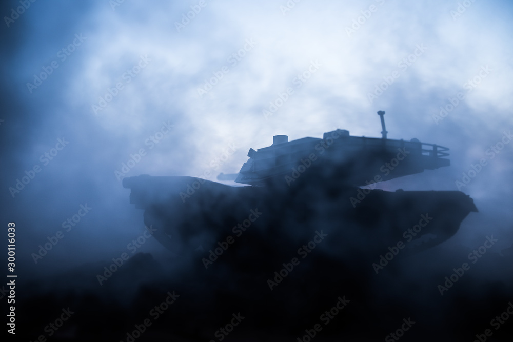 Fototapeta premium War Concept. Armored vehicle silhouette fighting scene on war fog sky background. American tank at sunset.