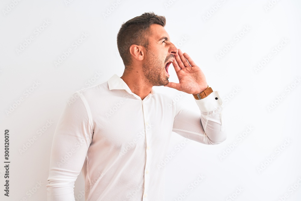 Young handsome business man wearing elegant shirt over isolated background shouting and screaming loud to side with hand on mouth. Communication concept. Young handsome business man wearing elegant shirt over isolated background shouting and screaming loud to side with hand on mouth. Communication concept.