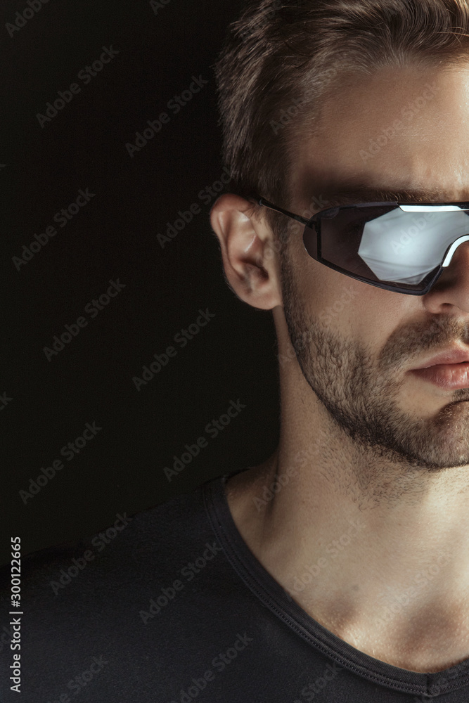 Muscle strong beautiful stripped male model with black t-shirt in denim blue jeans in glasses eyewear on black isolated font background Muscle strong beautiful stripped male model with black t-shirt in denim blue jeans in glasses eyewear on black isolated font background