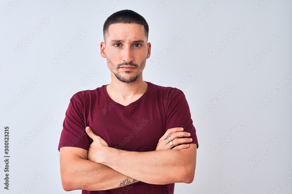 Young handsome man standing over isolated background skeptic and nervous, disapproving expression on face with crossed arms. Negative person. Young handsome man standing over isolated background skeptic and nervous, disapproving expression on face with crossed arms. Negative person.