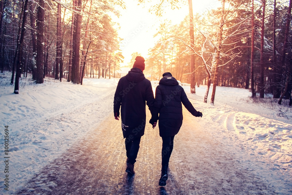 Couple Holding Hands Walking Away. Winter, Sunny, Forrest, Recreation, Leisure, Clothing. Couple Holding Hands Walking Away. Winter, Sunny, Forrest, Recreation, Leisure, Clothing.