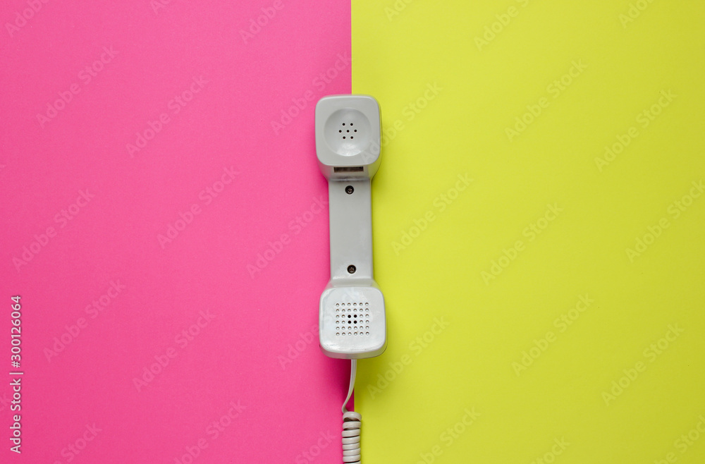 Three Retro telephone handset on neon color background. Pop culture. 80s. Minimalistic fashion shot. Top view Three Retro telephone handset on neon color background. Pop culture. 80s. Minimalistic fashion shot. Top view