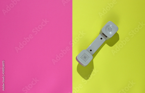 Three Retro telephone handset on neon color background. Pop culture. 80s. Minimalistic fashion shot. Top view