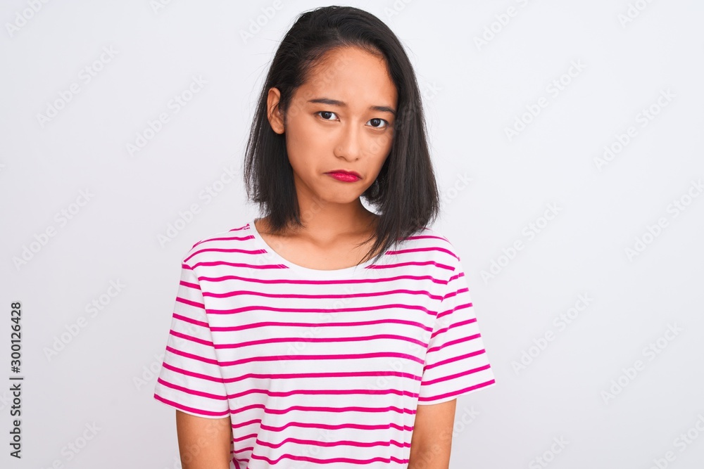 Young chinese woman wearing striped t-shirt standing over isolated white background depressed and worry for distress, crying angry and afraid. Sad expression. Young chinese woman wearing striped t-shirt standing over isolated white background depressed and worry for distress, crying angry and afraid. Sad expression.