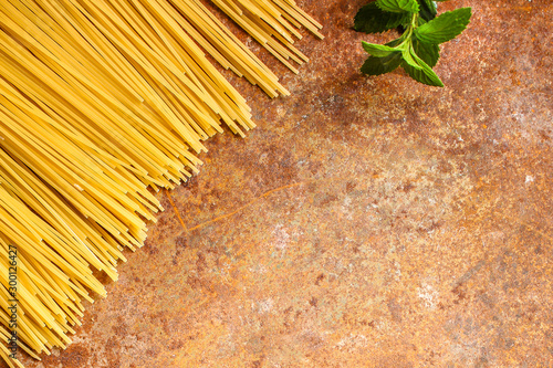 pasta raw, spaghetti or bucatini and tomato sauce ingredients. food background. copy space photo