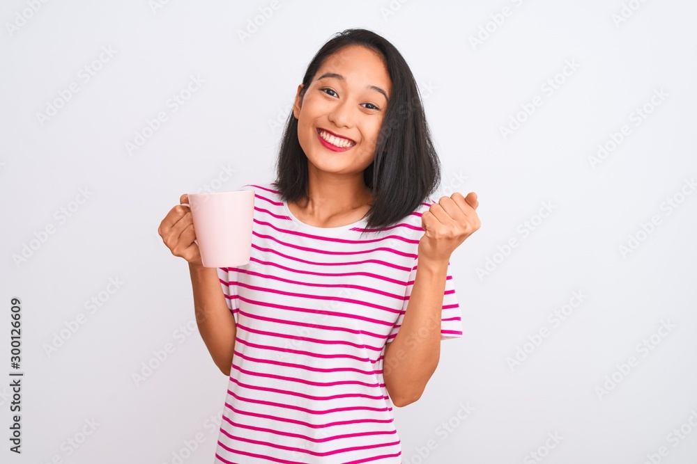 Young beautiful chinese woman drinking cup of coffee over isolated white background screaming proud and celebrating victory and success very excited, cheering emotion Young beautiful chinese woman drinking cup of coffee over isolated white background screaming proud and celebrating victory and success very excited, cheering emotion