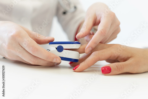 doctor puts a heart rate monitor on a patients finger