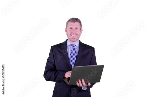 Smiling businessman using a laptop on studio