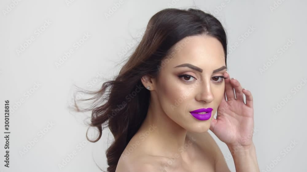 Portrait of pretty smiling woman with purple lips before white background, 100 FPS slowmotion Portrait of pretty smiling woman with purple lips before white background, 100 FPS slowmotion