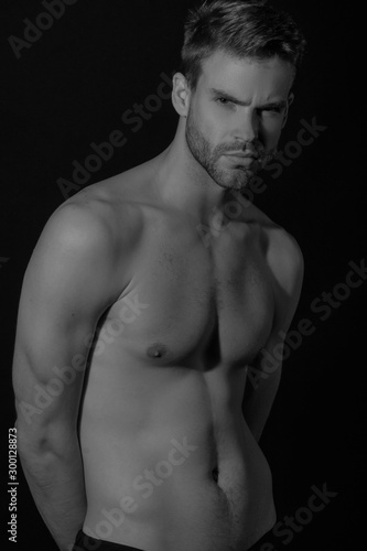 Black and White Strong stripped muscle male model in black underwear on black isolated font background