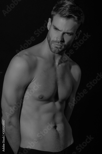 Black and White Strong stripped muscle male model in black underwear on black isolated font background
