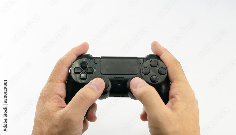Hands of caucasian man with wireless game console controller or joystick with buttons in black color on white background Hands of caucasian man with wireless game console controller or joystick with buttons in black color on white background