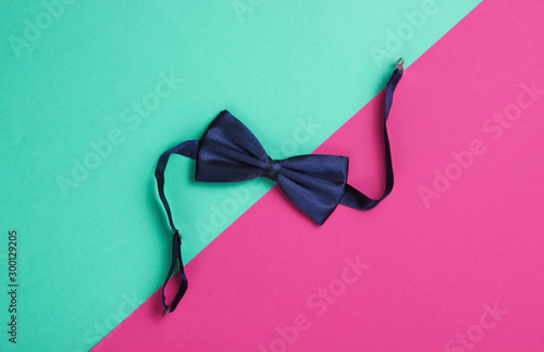Foto Bow tie on colored paper background. Top view.