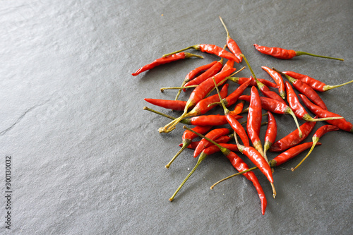 Bright red thai bird chiles on a gray slate background with copy space