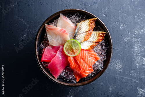 Sashimi japanese food, pieces of tuna, salmon, smoked eel with ice in bowl. Fish slices
