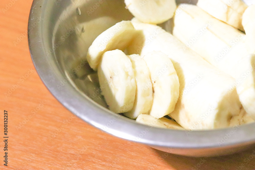 Sliced banana close-up in a metal plate on a brown background. Healthy foods for weight loss Sliced banana close-up in a metal plate on a brown background. Healthy foods for weight loss