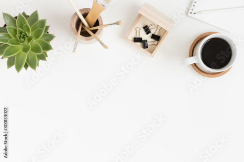 Workspace accessories, coffee and a succulent plant on a white table.  Flat lay with blank copy space. © Snoflinga