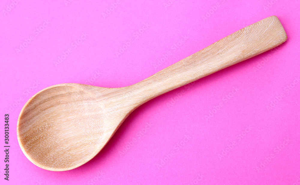 wooden spoon isolated on a pink background. wooden spoon isolated on a pink background.