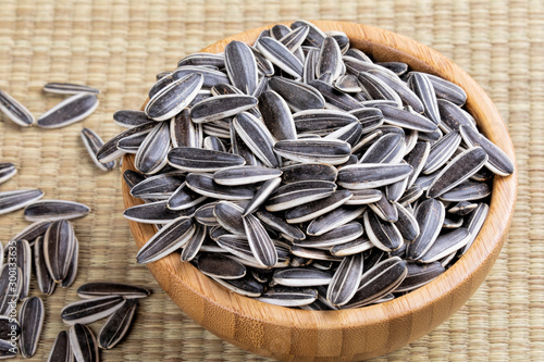 A wooden bowl full of sunflower seeds
