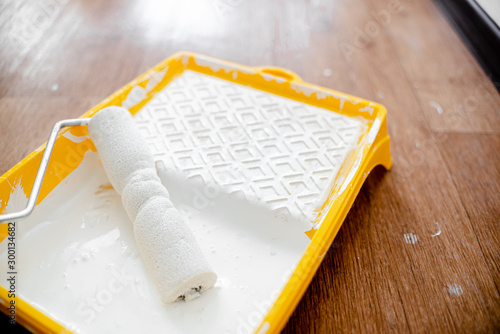 Foto Painting roller with white paint in yellow box