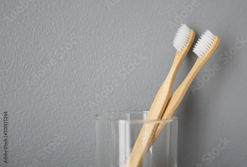 Close up wooden toothbrush in glass with grey background, selective focus