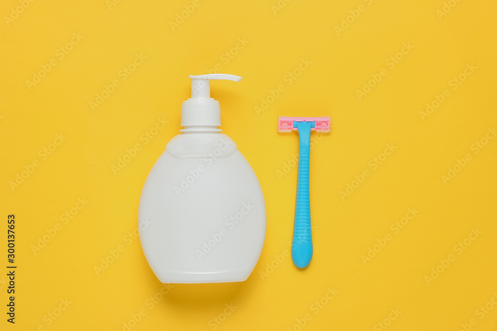 Bottle of gel for depilation, razor on yellow paper background. Pastel color trend. Minimalistic beauty concept. Top view Bottle of gel for depilation, razor on yellow paper background. Pastel color trend. Minimalistic beauty concept. Top view