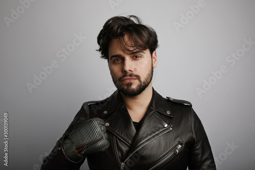 Studio portrait of young bearded hipster looking at the camera. photo