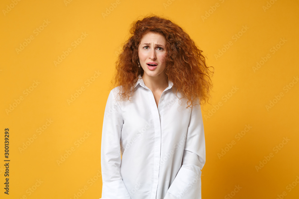 Irritated shocked tired young redhead woman girl in casual white shirt posing isolated on yellow orange wall background, studio portrait. People sincere emotions lifestyle concept. Mock up copy space. Irritated shocked tired young redhead woman girl in casual white shirt posing isolated on yellow orange wall background, studio portrait. People sincere emotions lifestyle concept. Mock up copy space.