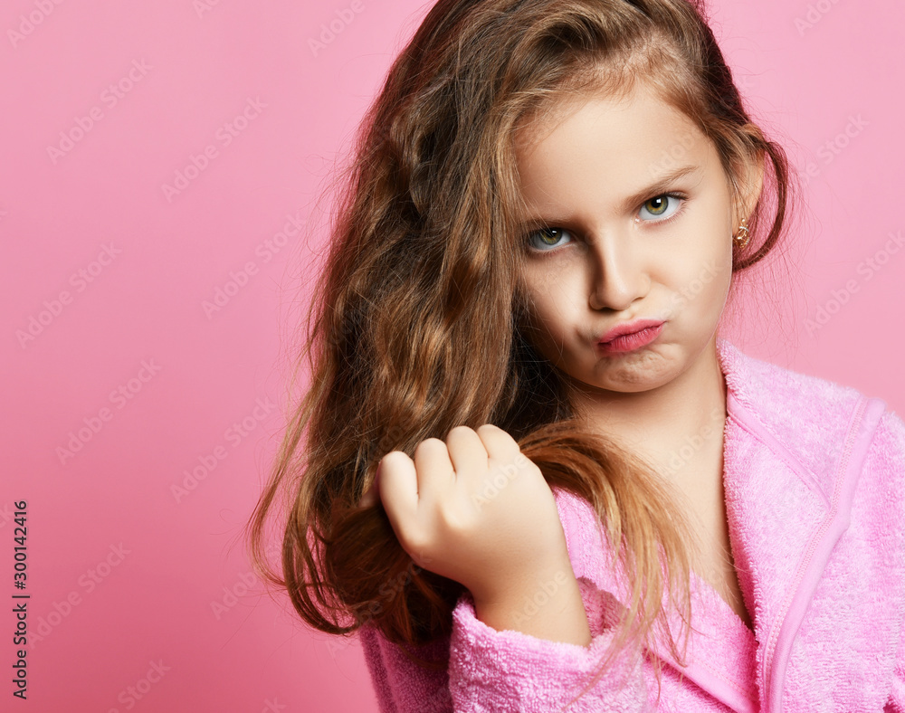 Baby girl or teen girl in spa salon is frightened with her hair style condition or something stuck or split ends of hair Baby girl or teen girl in spa salon is frightened with her hair style condition or something stuck or split ends of hair