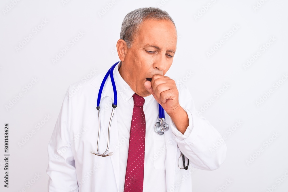 Senior grey-haired doctor man wearing stethoscope standing over isolated white background feeling unwell and coughing as symptom for cold or bronchitis. Healthcare concept. Senior grey-haired doctor man wearing stethoscope standing over isolated white background feeling unwell and coughing as symptom for cold or bronchitis. Healthcare concept.