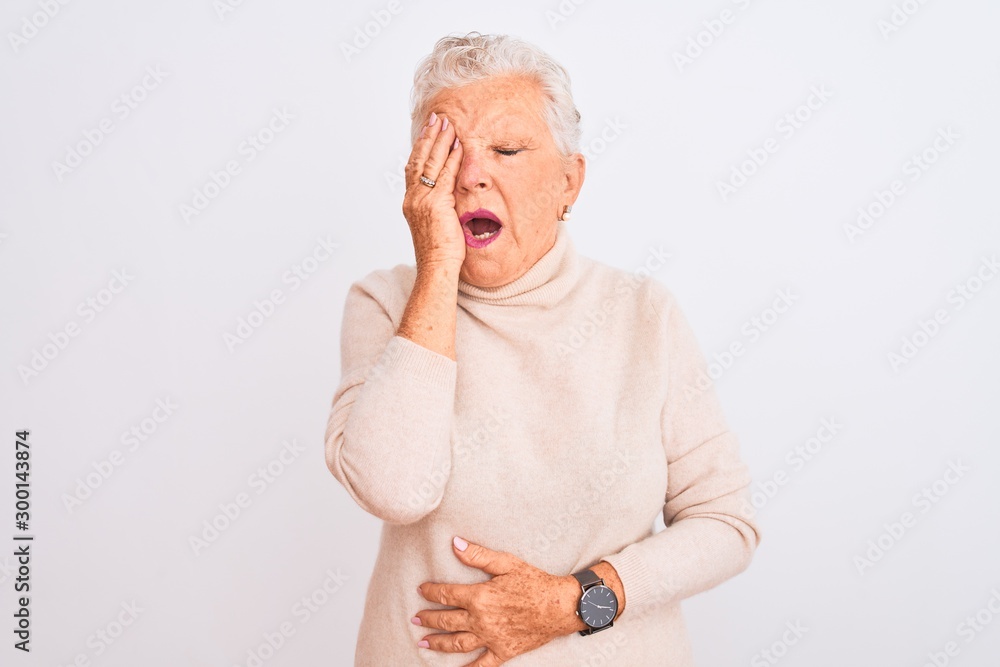 Senior grey-haired woman wearing turtleneck sweater standing over isolated white background Yawning tired covering half face, eye and mouth with hand. Face hurts in pain. Senior grey-haired woman wearing turtleneck sweater standing over isolated white background Yawning tired covering half face, eye and mouth with hand. Face hurts in pain.